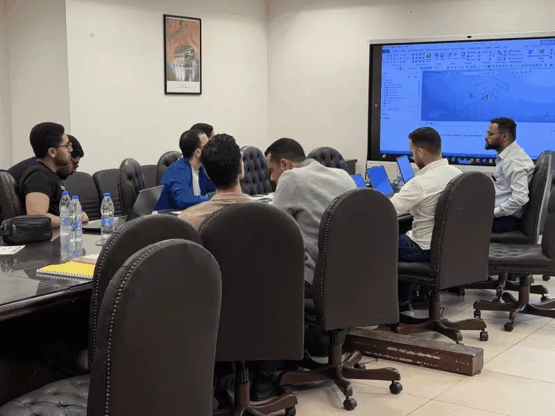 Engineers following a MIDAS GTS NX model on a large screen